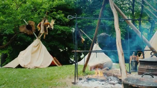 Indiánok táboroznak az erdőben. Az amerikai őslakosok régi táborának utánzása — Stock videók