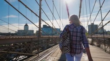 Kaygısız turist Brooklyn Köprüsü boyunca Brooklyn 'e doğru yürüyor. New York 'ta sabah