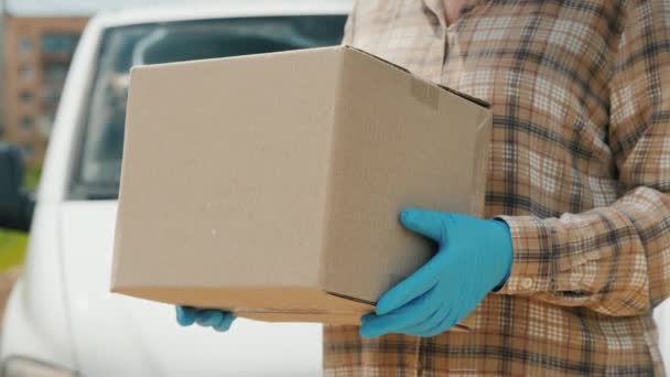 Übergabe des Pakets an den Empfänger im Hintergrund eines weißen Lieferwagens — Stockvideo