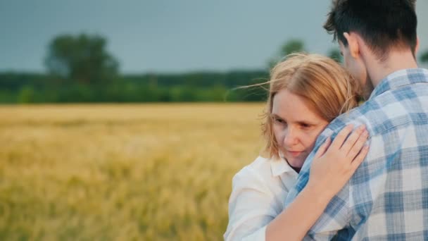 Žena se přitulí k mužskému rameni, silný vítr jí rozdrtí vlasy — Stock video