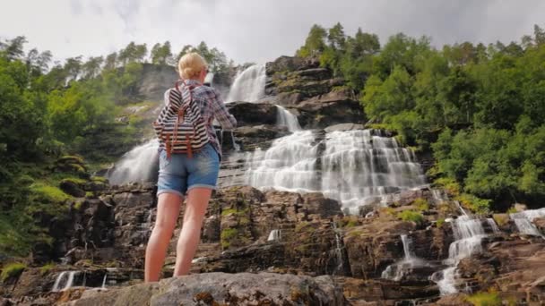 Wanita memotret air terjun tertinggi di Norwegia. Tampilan belakang — Stok Video