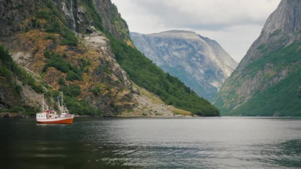 Un pequeño barco en las aguas de un majestuoso fiordo en Noruega. — Vídeo de stock