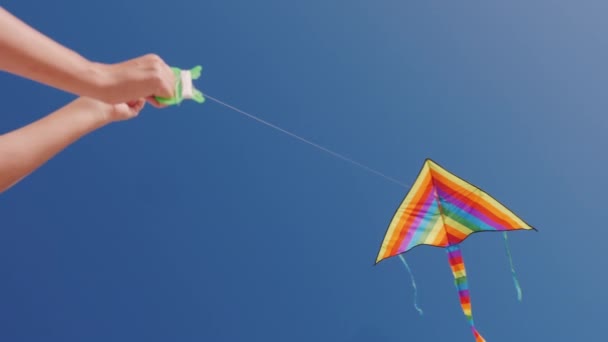 Man controleert vlieger die zweeft in blauwe wolkenloze lucht — Stockvideo