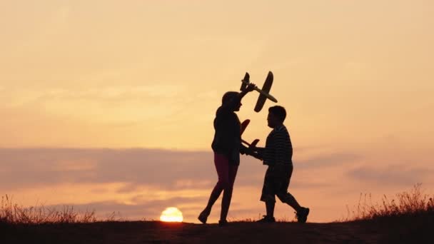 Kinderen spelen vliegtuigpiloten - samen plezier maken bij zonsondergang op een pittoreske plek — Stockvideo