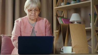 Yaşlı kadın dizüstü bilgisayardaki video bağlantısıyla arkadaşlarıyla iletişim kuruyor