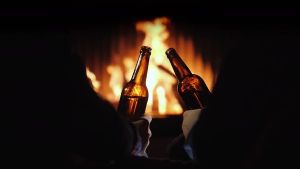 Descanso masculino com cerveja junto à lareira. Fuga de inverno — Vídeo de Stock