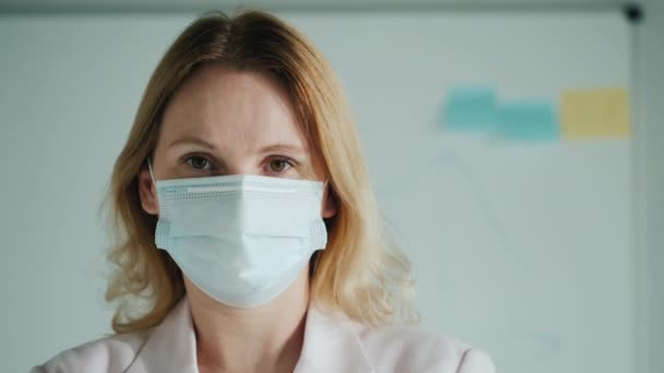 Portrait of a teacher in a medical mask against the background of a classroom board — Stock Video