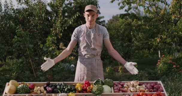 Stolt ung bonde vid disken med grönsaker från sitt fält — Stockvideo