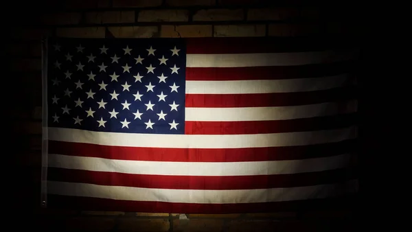 U.S. flag in the dark illuminated by spotlight — Stock Photo, Image