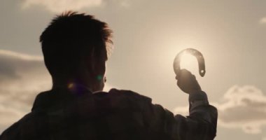 Güneşte elinde bir ata bakan bir adamın silueti iyi şansın sembolüdür.