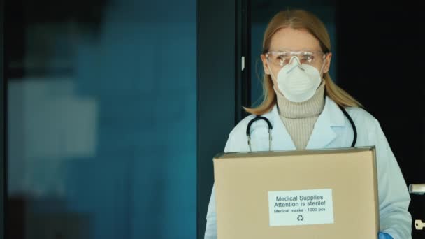 Портрет женщины-врача с коробкой защитных медицинских масок. — стоковое видео