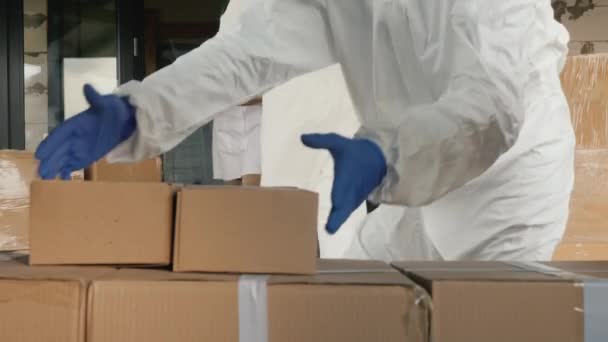 Перевізники в антивірусних костюмах розвантажують коробки ліків — стокове відео