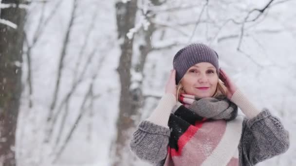 Een jonge vrouw geniet van een wandeling in het besneeuwde bos — Stockvideo