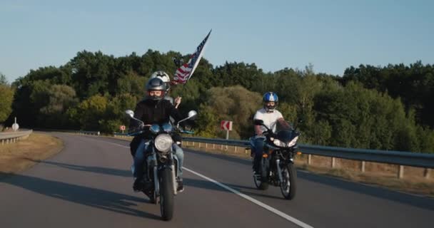 Байкеры с флагом США едут по шоссе. Концепция свободы и аллюзии — стоковое видео