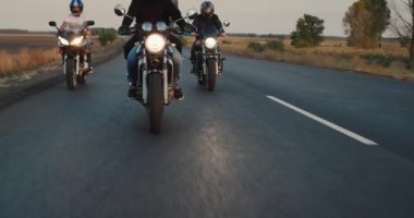 Bir grup motorcu düz bir otoyolda gidiyor, tekerleklerin altında parlayan yolları işaretliyorlar. Özgürlük ve Seyahat Konsepti