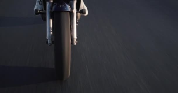 倾斜射击：在一个清澈的秋日，一个骑摩托车的年轻人骑着摩托车沿着风景如画的田野驰骋 — 图库视频影像
