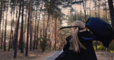 Okul çantalı neşeli bir kız parkta koşuyor. Yavaş çekim videosu