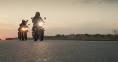 Amerikan bayrağı taşıyan motorcuların siluetleri, otobandan geçiyor. Yavaş çekim videosu