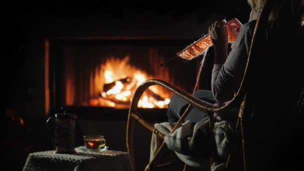 Loisirs d'hiver - tricots femme assis près du fireplac — Video