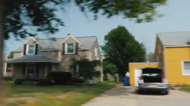 Un viaje de verano a América y un suburbio típico. Vista de la ventana de las casas americanas con césped cuidado — Vídeos de Stock
