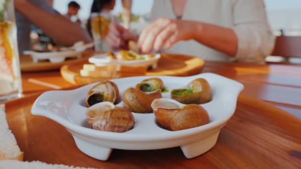 Los turistas degustan caracoles - un exquisito plato de cocina francesa — Vídeo de stock