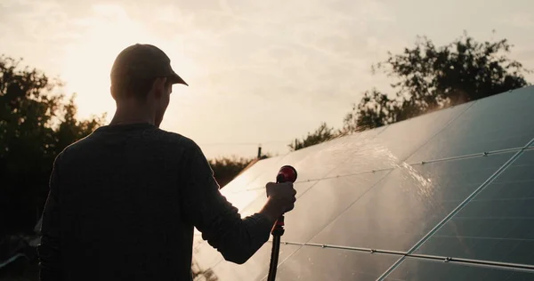 一个人洗太阳能电池板的轮廓 — 图库照片