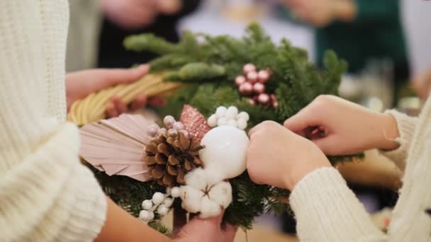 Mujer con niño fija joyas en la corona de Navidad — Vídeos de Stock