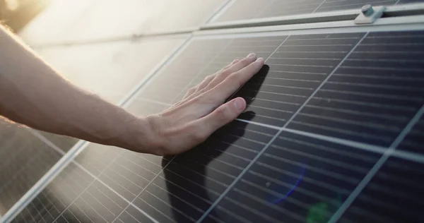 A férfiak kézzel simogatják a napelemek felületét. — Stock Fotó