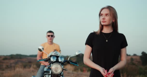 Ritratto di una giovane donna, dietro un ragazzo in moto — Video Stock