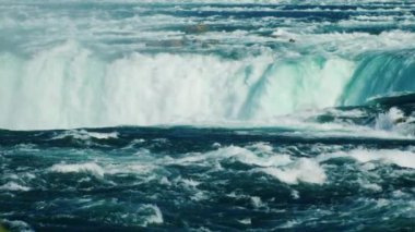 Güzel bir gölgesi olan su akıntısı aşağı doğru akar. Suyun üstünde gökkuşağı. Niagara Şelalesi
