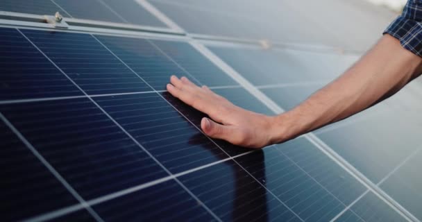 Mens hand strokes the surface of solar panels — Stock Video