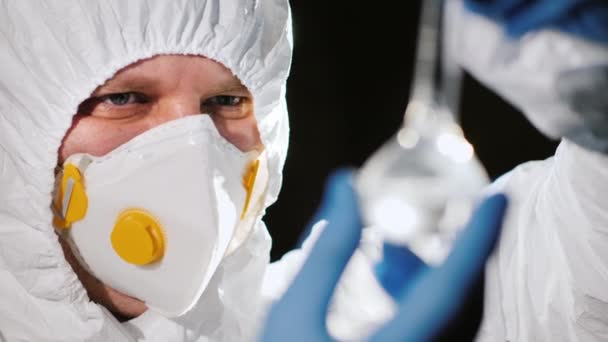 Retrato de un investigador sosteniendo un frasco de vidrio con reactivos químicos — Vídeos de Stock