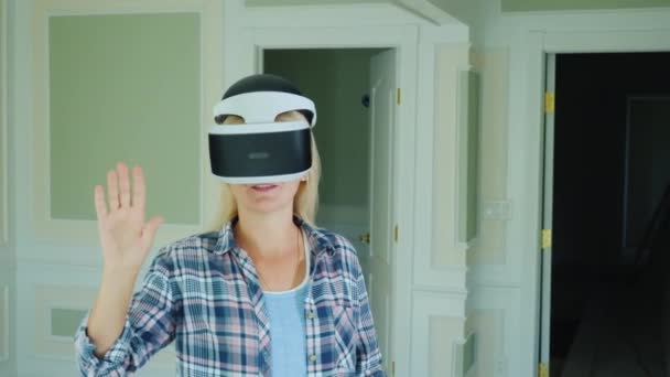 Женщина-дизайнер интерьера смотрит на проект в шлеме виртуальной реальности — стоковое видео