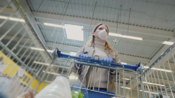 Γυναίκα ψώνια σε προστατευτική μάσκα κατά τη διάρκεια της πανδημίας coronavirus — Αρχείο Βίντεο