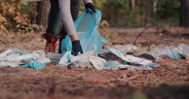 Μια γυναίκα αφαιρεί σκουπίδια από ιατρικές μάσκες και πλαστικά στο δάσος — Αρχείο Βίντεο