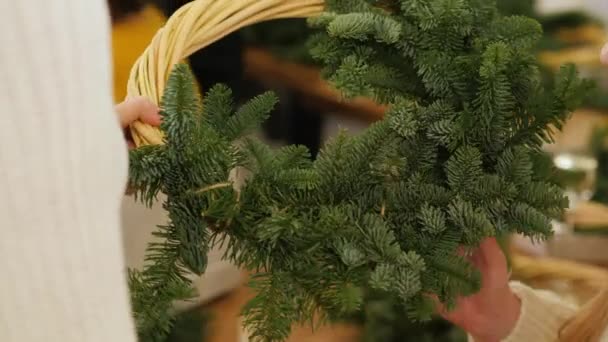 Mãos de mulher e bebê fazem grinalda de Natal de coníferas — Vídeo de Stock