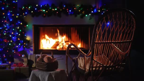 Ein Ort der winterlichen Entspannung - ein Schaukelstuhl am Kamin und ein Set für Handarbeiten in der Nähe — Stockvideo