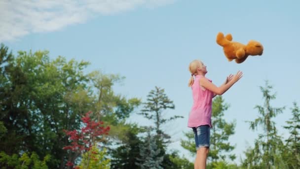 Молода жінка розважається - стрибає з іграшкою на батуті на задньому дворі — стокове відео