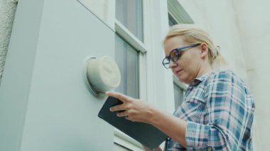 Kadın elektrik sayacı ölçümlerini kaydediyor