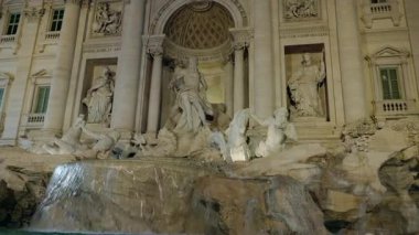 Trevi Çeşmesi gece Roma 'da heykeller ve akan suyla aydınlandı. Yüksek kalite 4k görüntü