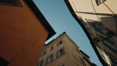 Yüksek tarihi binaları olan dar bir Roma sokağı ve çatıların arkasından gün ışığı gözetlemek üzere. Yüksek kalite 4k görüntü