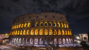 Roma 'daki aydınlanmış Kolezyum' un gece zamanlaması parlayan ışıkları ve şehir atmosferini uzun süre yansıtıyor. Yüksek kalite 4k görüntü