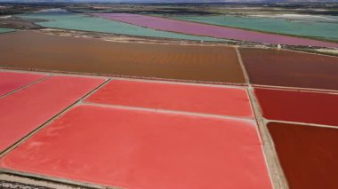 Santa Pola, Alicante, İspanya yakınlarındaki renkli tuz buharlaştırma havuzlarının insansız hava aracı görüntüsü. Pembe, kırmızı, turuncu ve yeşil suyu olan geometrik desenler. Yüksek kalite 4k görüntü