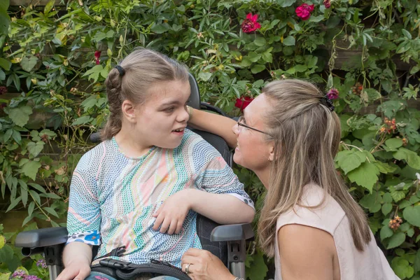 Bir Engelli çocuğu için bir gönüllü bakım işçisi tarafından bakım tekerlekli sandalyede.