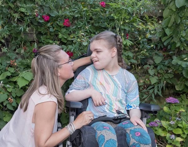 自主的な介護福祉士を気遣われて車椅子で障害児. — ストック写真