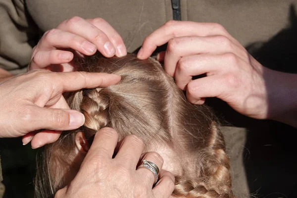 Vérification des cheveux d'une jeune fille pour les poux de tête — Photo