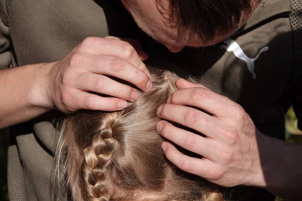 Vérification des cheveux d'une jeune fille pour les poux de tête — Photo