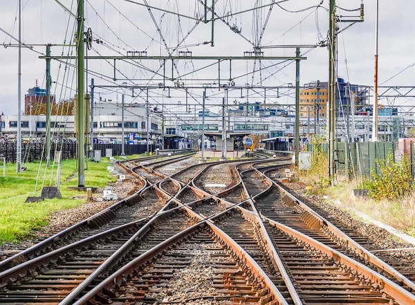 Uma visão abstrata dos trilhos ferroviários que levam a uma estação movimentada . — Fotografia de Stock