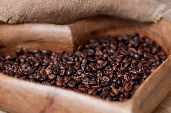 Coffee beans and a cup of espresso on a wooden tray in the form of a heart