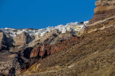 Santorini Adası'nda kayalık sahil ve deniz beyaz şehir görüntüsü